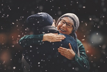 2 people embracing in a light snowfall