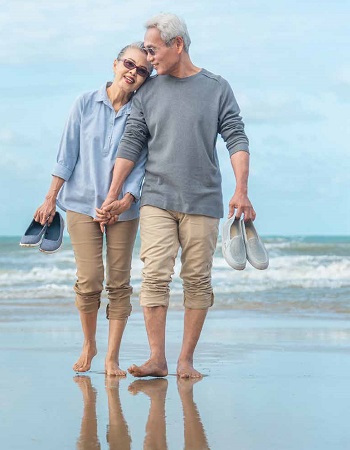 older couple walking on beach