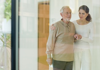 woman helping older man while walking